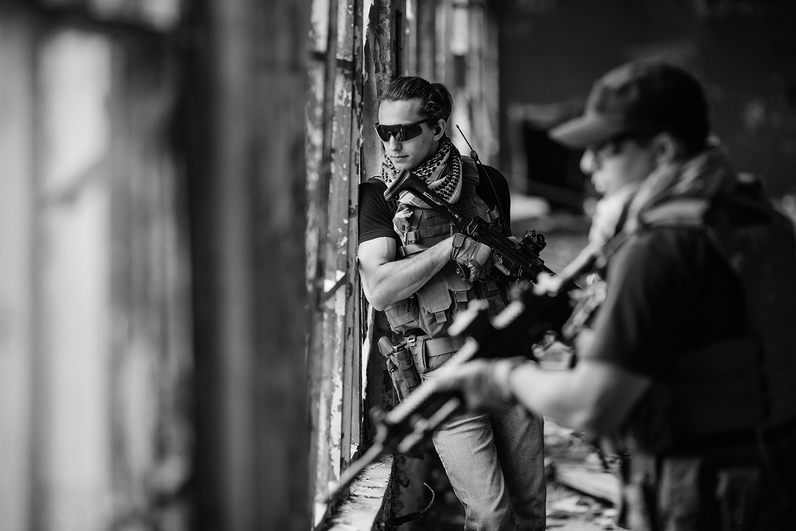 Private security contractors with PDWs pulling security in a building.